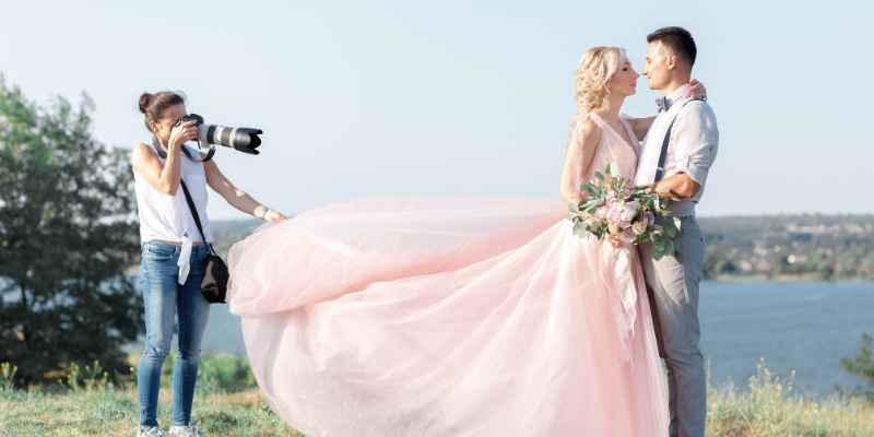 Photographer capturing wedding outdoors.